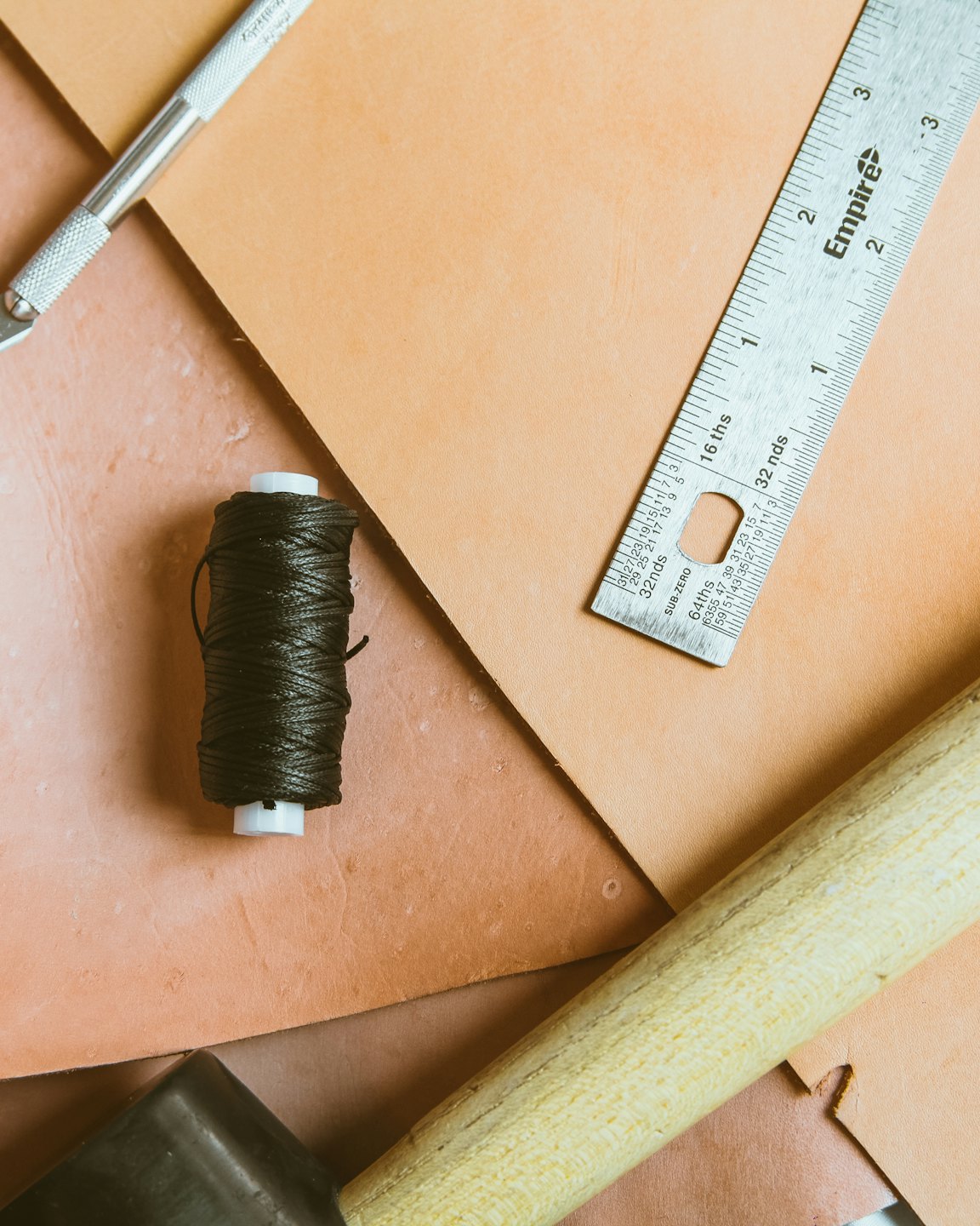 Attrezzi e materiali per la lavorazione del cuoio disposti per un progetto.