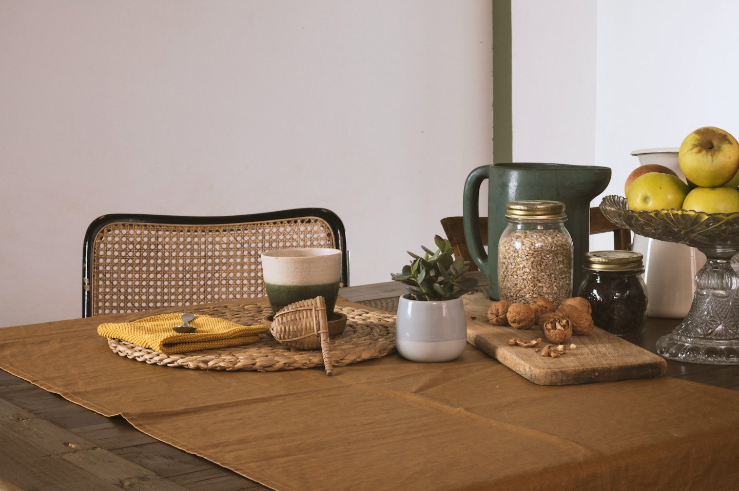 Un tavolo rustico di legno espone utensili da cucina e frutta fresca.
